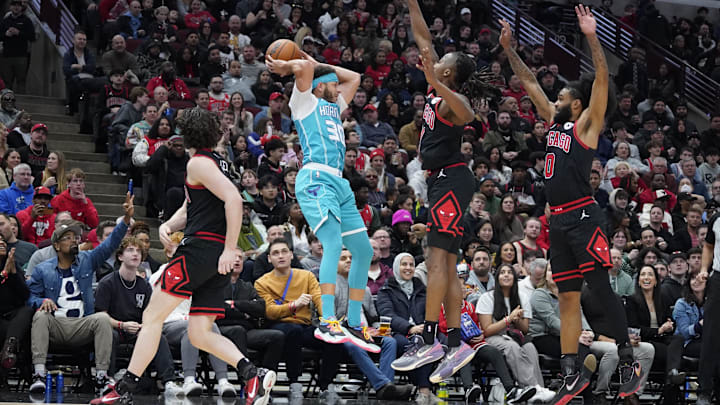 Jan 17, 2025; Chicago, Illinois, USA; Chicago Bulls guard Ayo Dosunmu (11), guard Coby White (0) defend Charlotte Hornets guard Seth Curry (30) during the second half at United Center. Mandatory Credit: David Banks-Imagn Images