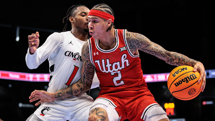 Mar 10, 2026; Kansas City, MO, USA; Utah Utes guard Terrence Brown (2) drives around Cincinnati Bearcats guard Day Day Thomas (1) during the second half at T-Mobile Center. Mandatory Credit: William Purnell-Imagn Images