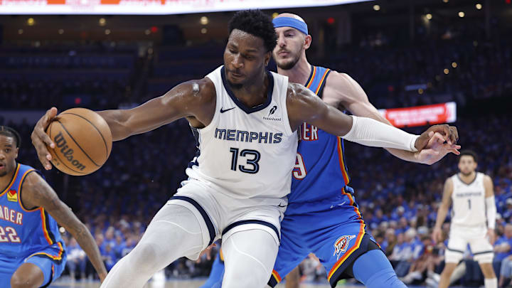 Apr 22, 2025; Oklahoma City, Oklahoma, USA; Memphis Grizzlies forward Jaren Jackson Jr. (13) moves the ball against Oklahoma City Thunder guard Alex Caruso (9) in the third quarter during game two of first round for the 2024 NBA Playoffs at Paycom Center. Mandatory Credit: Alonzo Adams-Imagn Images