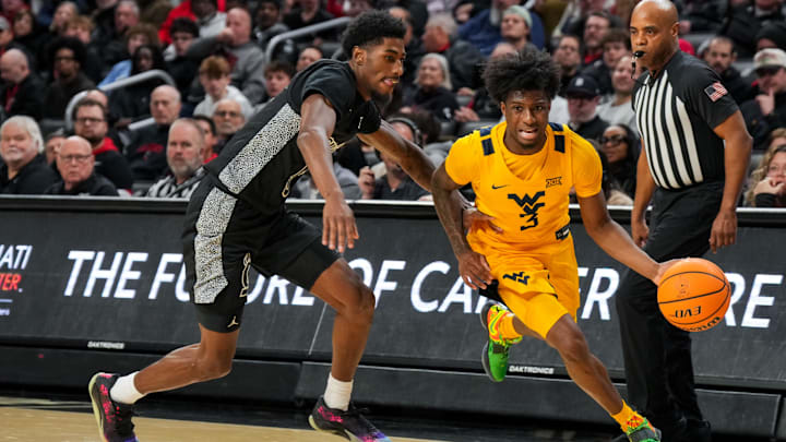 Feb 5, 2026; Cincinnati, Ohio, USA;  West Virginia Mountaineers guard Honor Huff (3) dribbles the ball against Cincinnati Bearcats guard Sencire Harris (5) in the second half at Fifth Third Arena. Mandatory Credit: Aaron Doster-Imagn Images