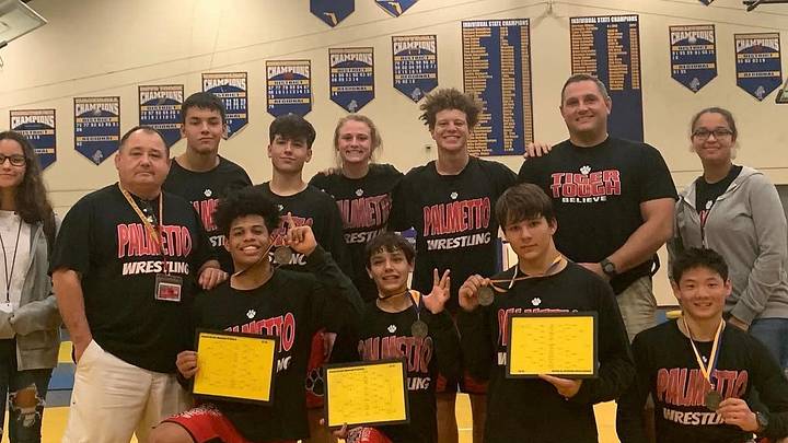Late Palmetto wrestling coach Bryan Wilkes, second row far left, stands with his team following a successful tournament finish in December of 2019. Wilkes, 63, coached the Tigers for 17 years. Late Palmetto wrestling coach Bryan Wilkes, second row far left, stands with his team following a successful tournament finish in December of 2019. Wilkes, 63, coached the Tigers for 17 years.