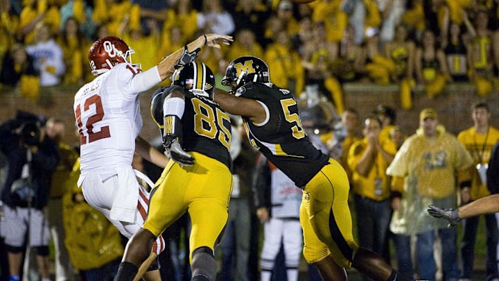 Oct 23, 2010; Columbia, MO, USA; Oklahoma Sooners quarterback Landry Jones (12) is pressured by Missouri Tigers defensive end Aldon Smith (85) and Tigers defensive lineman Michael Sam (52) during the second half at Faurot Field at Memorial Stadium. Mandatory Credit: Photo by Scott Rovak-Imagn Images