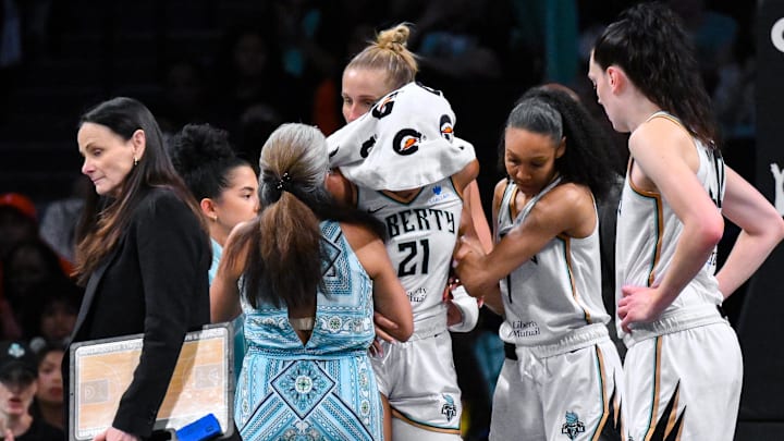 Jul 6, 2025; Brooklyn, New York, USA; New York Liberty forward Isabelle Harrison (21) is assisted off the court after an injury during the second half against the Seattle Storm at Barclays Center. Mandatory Credit: John Jones-Imagn Images