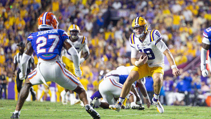 Sep 13, 2025; Baton Rouge, Louisiana, USA;  LSU Tigers quarterback Garrett Nussmeier (18) scrambles against Florida Gators defensive back Dijon Johnson (27) during the first half at Tiger Stadium. Mandatory Credit: Stephen Lew-Imagn Images