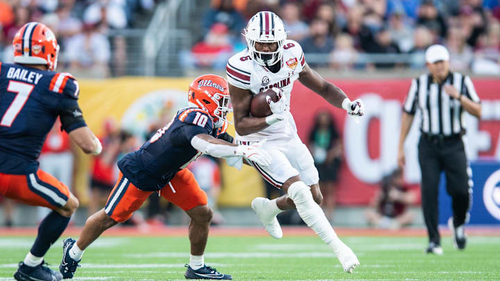 Dec 31, 2024; Orlando, FL, USA; South Carolina Gamecocks running back Dylan Stewart (6) runs the ball against Illinois Fighting Illini defensive back Miles Scott (10) in the third quarter at Camping World Stadium. Mandatory Credit: Jeremy Reper-Imagn Images