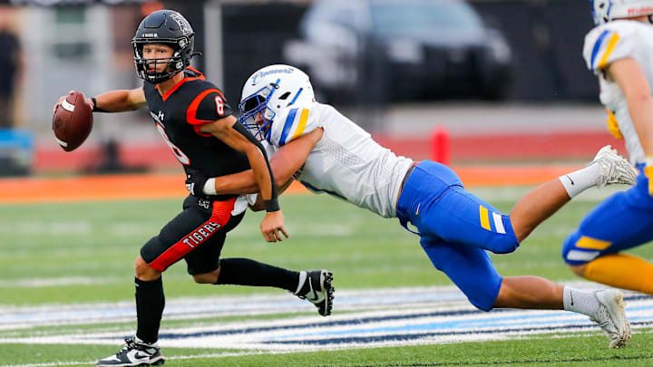 Norman   s Phoenix Murphy (6) is sacked by Stillwater   s Nehemiah Kolone (7) during a high school football game between Stillwater High School and Norman High School in Norman, Okla., on Thursday, Sept. 14, 2023.