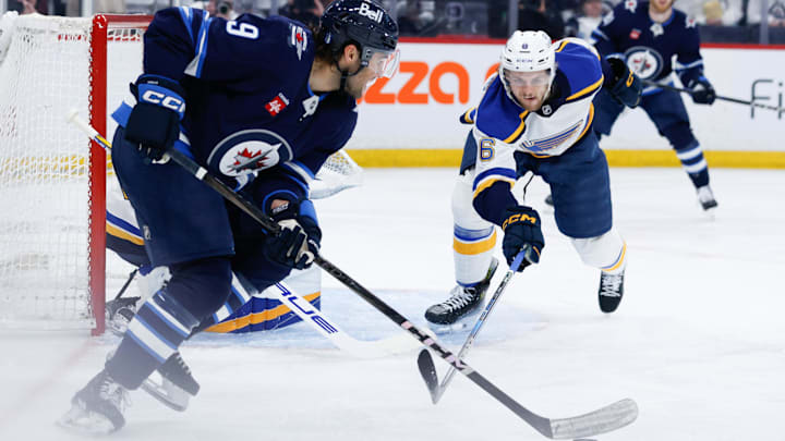 Apr 19, 2025; Winnipeg, Manitoba, CAN; St. Louis Blues defenseman Philip Broberg (6) skates into Winnipeg Jets forward Alex Iafallo (9) during the second period in game one of the first round of the 2025 Stanley Cup Playoffs at Canada Life Centre. Mandatory Credit: Terrence Lee-Imagn Images