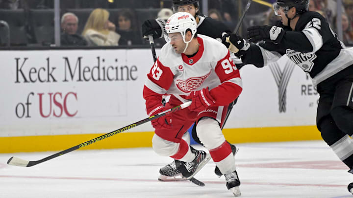 Nov 16, 2024; Los Angeles, California, USA; Detroit Red Wings right wing Alex DeBrincat (93) keeps the puck from Los Angeles Kings center Phillip Danault (24) and left wing Kevin Fiala (22) in the first period at Crypto.com Arena. Mandatory Credit: Jayne Kamin-Oncea-Imagn Images