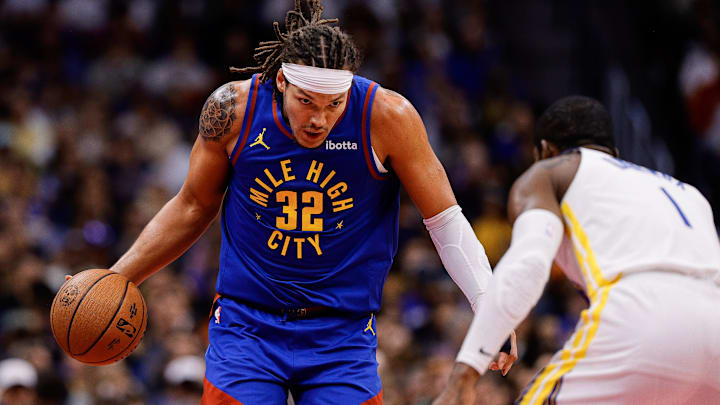 Nov 7, 2025; Denver, Colorado, USA; Denver Nuggets forward Aaron Gordon (32) controls the ball as Golden State Warriors forward Jonathan Kuminga (1) guards in the third quarter at Ball Arena. Mandatory Credit: Isaiah J. Downing-Imagn Images