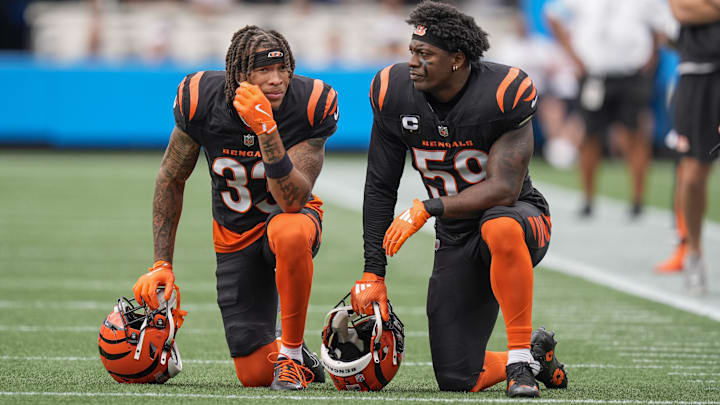Sep 29, 2024; Charlotte, North Carolina, USA; Cincinnati Bengals safety Daijahn Anthony (33) and linebacker Akeem Davis-Gaither (59) take a knee for an injured player against the Carolina Panthers during 1st quarter at Bank of America Stadium. Mandatory Credit: Jim Dedmon-Imagn Images