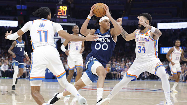 Feb 24, 2025; Oklahoma City, Oklahoma, USA; Minnesota Timberwolves guard Terrence Shannon Jr. (00) drives between Oklahoma City Thunder guard Isaiah Joe (11) and  forward Kenrich Williams (34) on the way to the basket during the second half at Paycom Center. Mandatory Credit: Alonzo Adams-Imagn Images
