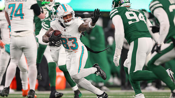 Miami Dolphins wide receiver Malik Washington (83) gains yards after catch asNew York Jets defensive end Solomon Thomas (94) pursues during the second half at MetLife Stadium in the 2024 season finale.