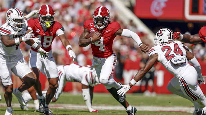 Oct 12, 2024; Tuscaloosa, Alabama, USA;  Alabama Crimson Tide quarterback Jalen Milroe (4) carries the ball for a first down as he gets around South Carolina Gamecocks defensive back Jalon Kilgore (24) during the first half at Bryant-Denny Stadium. Mandatory Credit: Butch Dill-Imagn Images