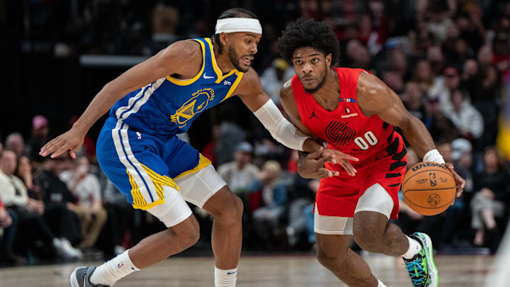 Oct 23, 2024; Portland, Oregon, USA;  Portland Trailblazers guard Scoot Henderson (00) dribbles the ball against Golden State Warriors shooting guard Moses Moody (4) during the first half at Moda Center. Mandatory Credit: Stephen Brashear-Imagn Images
