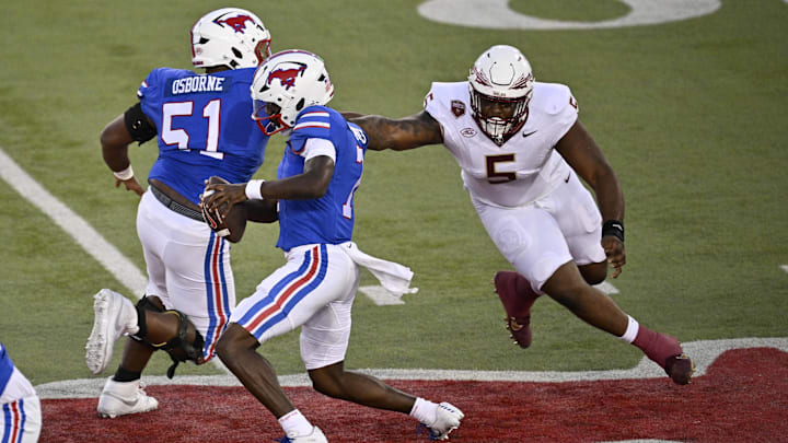 Sep 28, 2024; Dallas, Texas, USA; Southern Methodist Mustangs offensive lineman Justin Osborne (51) and quarterback Kevin Jennings (7) and Florida State Seminoles defensive lineman Joshua Farmer (5) in action during the game between the Southern Methodist Mustangs and the Florida State Seminoles at Gerald J. Ford Stadium.  