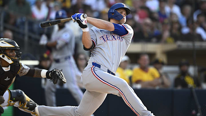 Jul 6, 2025; San Diego, California, USA; Texas Rangers shortstop Corey Seager (5) hits an RBI double during the first inning against the San Diego Padres at Petco Park. 