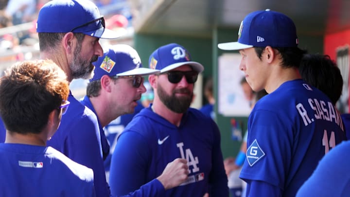 Mar 3, 2026; Goodyear, Arizona, USA; Los Angeles Dodgers starting pitcher Roki Sasaki (11) talks with coaches during the fourth inning of the game against he Cleveland Guardians at Goodyear Ballpark. Mandatory Credit: Joe Camporeale-Imagn Images