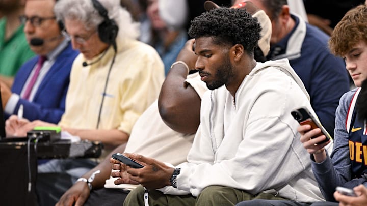Jan 14, 2025; Dallas, Texas, USA; Colorado Buffaloes quarterback Shedeur Sanders checks his phone during the game between the Dallas Mavericks and the Denver Nuggets in the second quarter at the American Airlines Center. Mandatory Credit: Jerome Miron-Imagn Images