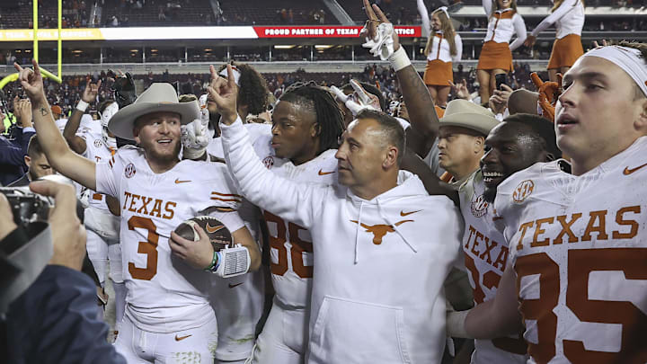 Nov 30, 2024; College Station, Texas, USA; Texas Longhorns quarterback Quinn Ewers (3) celebrates with head coach Steve Sarkisian and teammates after the game against the Texas A&M Aggies at Kyle Field. Mandatory Credit: Troy Taormina-Imagn Images Nov 30, 2024; College Station, Texas, USA; Texas Longhorns quarterback Quinn Ewers (3) celebrates with head coach Steve Sarkisian and teammates after the game against the Texas A&M Aggies at Kyle Field. Mandatory Credit: Troy Taormina-Imagn Images