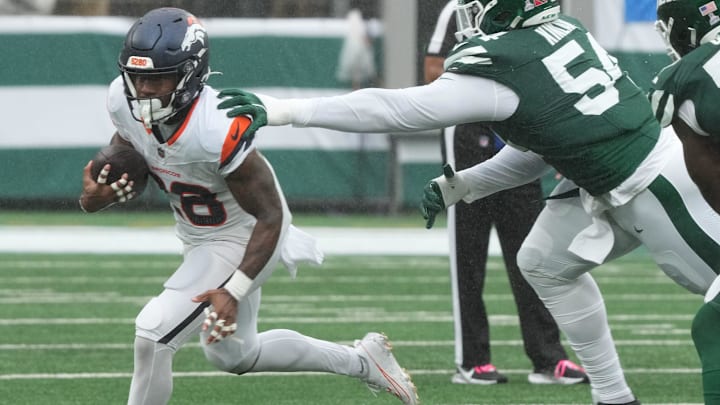 East Rutherford, NJ -- September 29 -- Tyler Badie of Denver runs from Javon Kinlaw of the Jets in the first half as the Denver Broncos edged the New York Jets 10-9 at MetLife Stadium.