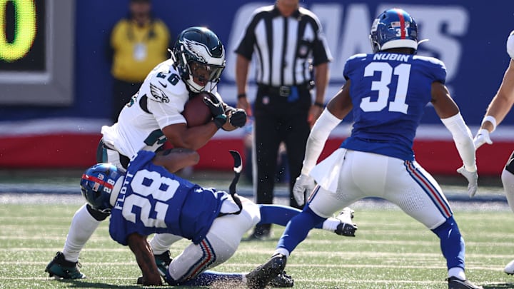 Oct 20, 2024; East Rutherford, New Jersey, USA; Philadelphia Eagles running back Saquon Barkley (26) is tackled by New York Giants cornerback Cor'Dale Flott (28) in front of safety Tyler Nubin (31) during the first half at MetLife Stadium.  