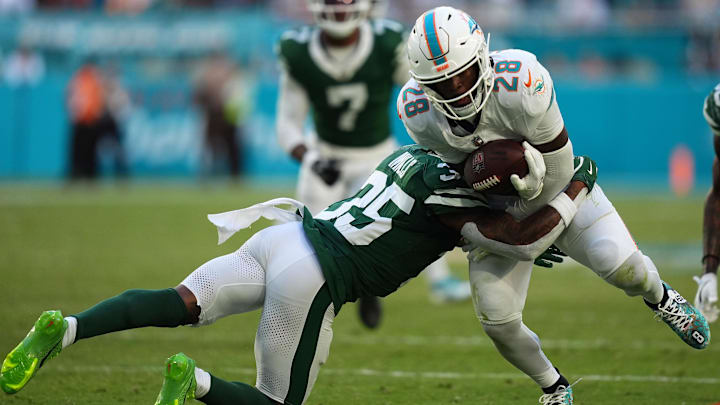 New York Jets safety Jalen Mills (35) attempts to tackle Miami Dolphins running back De'Von Achane (28) during overtime at Hard Rock Stadium.