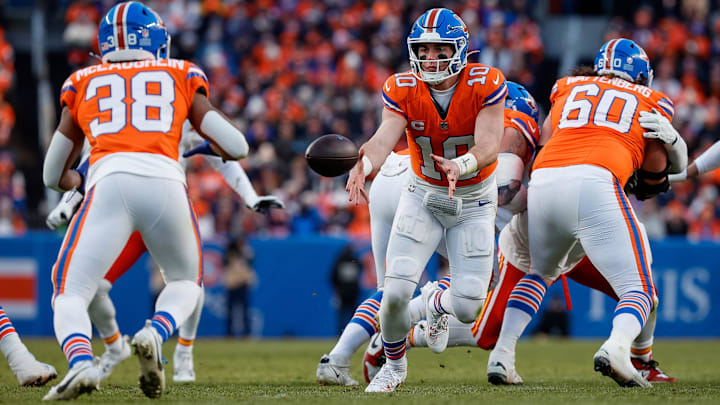 Jan 5, 2025; Denver, Colorado, USA; Denver Broncos quarterback Bo Nix (10) pitches the ball to running back Jaleel McLaughlin (38) as center Luke Wattenberg (60) defends in the third quarter against the Kansas City Chiefs at Empower Field at Mile High. Mandatory Credit: Isaiah J. Downing-Imagn Images