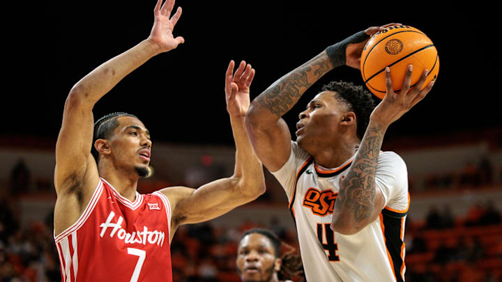 Mar 7, 2026; Stillwater, Oklahoma, USA;  Oklahoma State Cowboys guard Christian Coleman (4) drives around Houston Cougars guard Milos Uzan (7) during the first half at Gallagher-Iba Arena. Mandatory Credit: William Purnell-Imagn Images