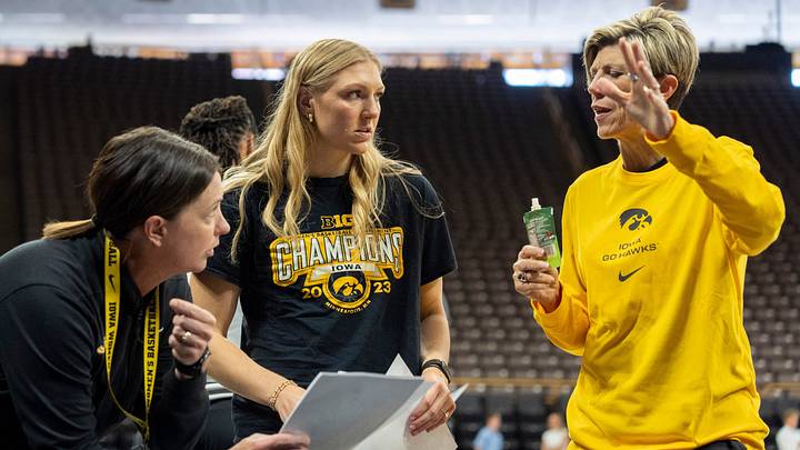 Iowa assistant coach Abby Stamp, left, and special assistant to the head coach Sydney Affolter, center, listen to coach Jan Jensen Oct. 13, 2026 during an Iowa women’s basketball practice at Carver-Hawkeye Arena in Iowa City, Iowa.