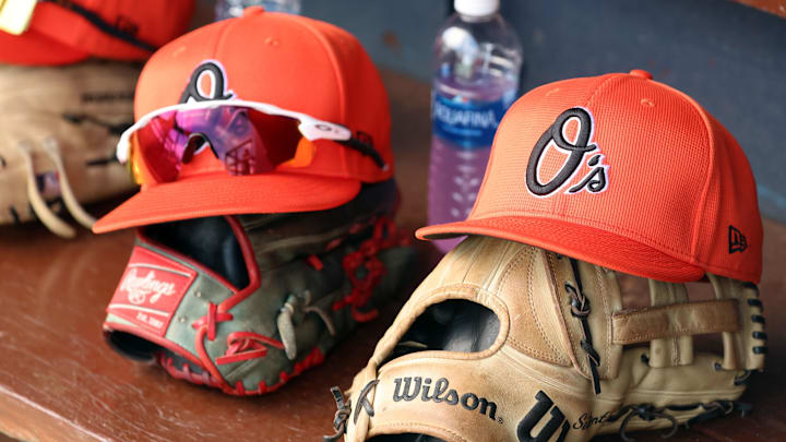 Mar 11, 2024; Tampa, Florida, USA; A detailed view of Baltimore Orioles baseball hats and gloves in the dugout during the first inning against the New York Yankees at George M. Steinbrenner Field. Mandatory Credit: Kim Klement Neitzel-Imagn Images Mar 11, 2024; Tampa, Florida, USA; A detailed view of Baltimore Orioles baseball hats and gloves in the dugout during the first inning against the New York Yankees at George M. Steinbrenner Field. Mandatory Credit: Kim Klement Neitzel-Imagn Images