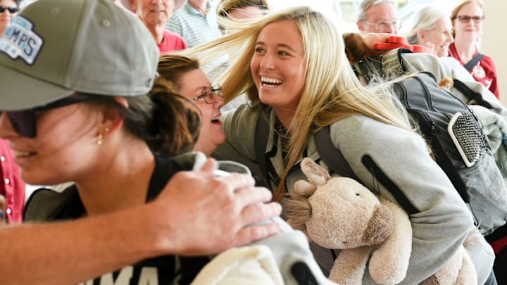 Alabama softball players are greeted by a devoted group of fans at the Tuscaloosa Regional Airport as the team leaves for the College World Series in Oklahoma. Kayla Beaver gets hugs from fans as she makes her way to the plane while carrying a stuffed animal.
