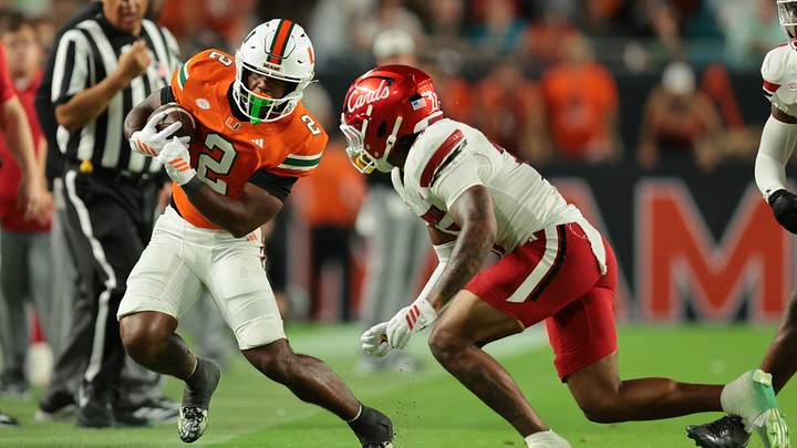 Oct 17, 2025; Miami Gardens, Florida, USA; Miami Hurricanes running back Jordan Lyle (2) runs out of bounds as Louisville Cardinals defensive back Jojo Evans Jr. (27) defends during the fourth quarter at Hard Rock Stadium. Mandatory Credit: Sam Navarro-Imagn Images