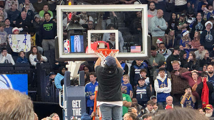A stadium worker fixes the hoop before a game between the Timberwolves and Golden State Warriors at Target Center in Minneapolis on Dec. 19, 2024. 