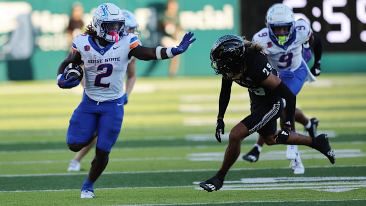 Ashton Jeanty applies the stiff arm  to Hawaii's defensive back Kilinahe Mendiola-Jensen.