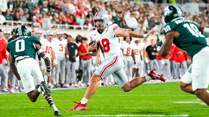 Sep 28, 2024; East Lansing, Michigan, USA; Ohio State Buckeyes quarterback Will Howard (18) runs the ball against the Michigan State Spartans in the first half at Spartan Stadium on Saturday.
