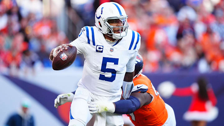 Dec 15, 2024; Denver, Colorado, USA; Indianapolis Colts quarterback Anthony Richardson (5) runs past the tackle of Denver Broncos defensive tackle Malcolm Roach (97) in the second quarter at Empower Field at Mile High. Mandatory Credit: Ron Chenoy-Imagn Images