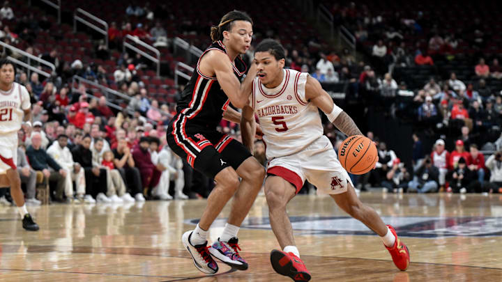 Dec 20, 2025; Newark, New Jersey, USA; Arkansas Razorbacks guard Darius Acuff Jr. (5) tries to drive past Houston Cougars guard Kingston Flemings (4) during the first half at Prudential Center. Mandatory Credit: John Jones-Imagn Images