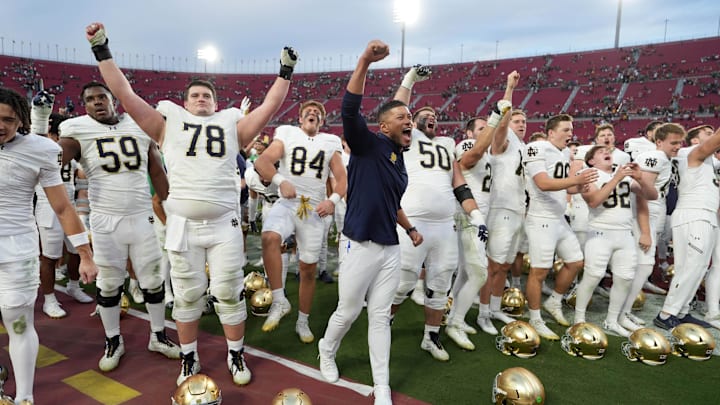 Nov 30, 2024; Los Angeles, California, USA; Notre Dame Fighting Irish head coach Marcus Freeman celebrates with players at the end of the game against the Southern California Trojans at United Airlines Field at Los Angeles Memorial Coliseum.