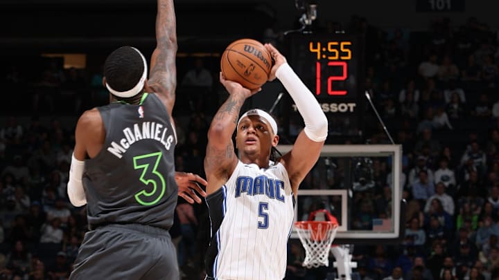 Orlando Magic forward Paolo Banchero attempts a three-pointer over Minnesota Timberwolves forward Jaden McDaniels.