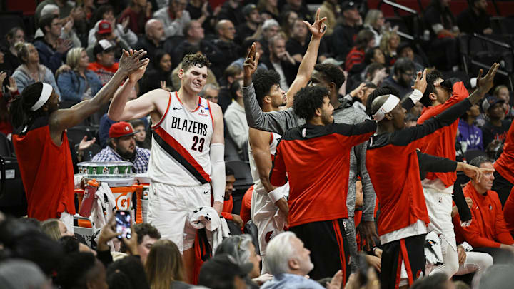 Oct 18, 2024; Portland, Oregon, USA; Portland Trail Blazers forward Jerami Grant (9), left, and center Donovan Clingan (23) celebrate with teammates during the second half against the Utah Jazz at Moda Center. Mandatory Credit: Troy Wayrynen-Imagn Images