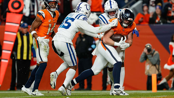 Dec 15, 2024; Denver, Colorado, USA; Denver Broncos tight end Nate Adkins (45) scores a touchdown against Indianapolis Colts linebacker E.J. Speed (45) and cornerback Jaylon Jones (40) as wide receiver Courtland Sutton (14) looks on in the fourth quarter at Empower Field at Mile High. Mandatory Credit: Isaiah J. Downing-Imagn Images