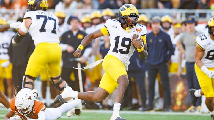 Michigan Wolverines quarterback Bryce Underwood (19) runs with the ball after breaking a tackle against the Texas Longhorns