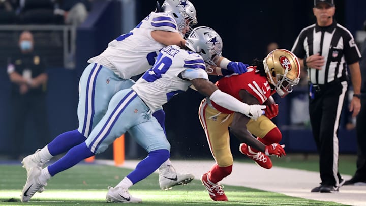Dallas Cowboys defenders tackle San Francisco 49ers wide receiver Brandon Aiyuk.