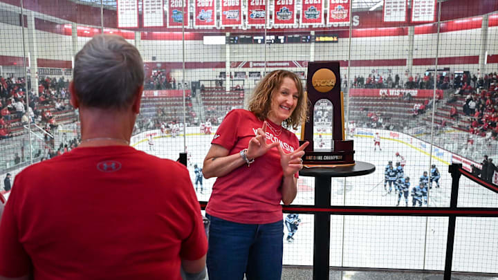 Kathy Butts Richardson of Madison poses with the 2025 NCAA women’s hockey national championship trophy won by Wisconsin before the game between Wisconsin and Maine on Friday, October 3, 2025, at LaBahn Arena in Madison, Wisconsin.