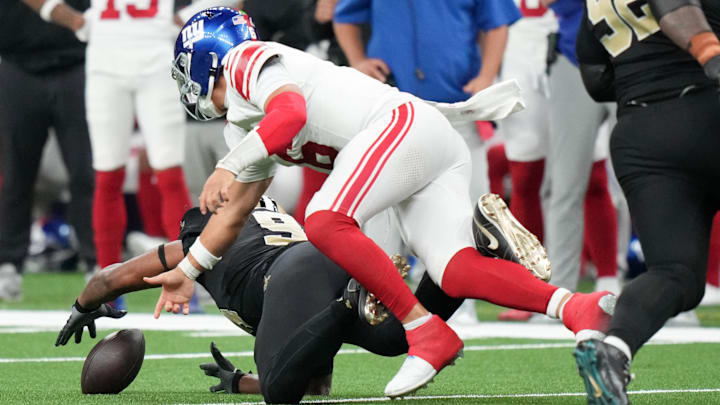Oct 5, 2025; New Orleans, Louisiana, USA; New Orleans Saints defensive end Cameron Jordan (94) recovers a fumble in front of New York Giants quarterback Jaxson Dart (6) during the third quarter at Caesars Superdome.  