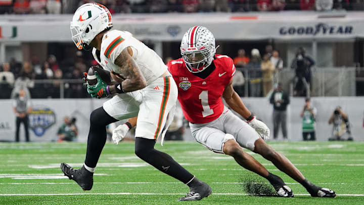 Miami Hurricanes wide receiver CJ Daniels (7) runs after the catch while defended by Ohio State Buckeyes cornerback Davison Igbinosun (1) in the second quarter during the 2025 Cotton Bowl and quarterfinal game of the College Football Playoff at AT&T Stadium. 