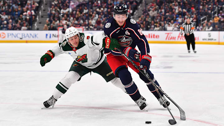 Blue Jackets defenseman Zach Werenski works against Minnesota Wild's Brock Faber. 