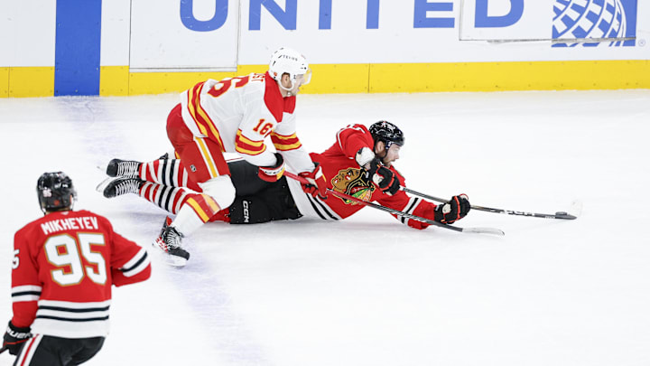 Jan 15, 2026; Chicago, Illinois, USA; Chicago Blackhawks center Jason Dickinson (16) defends against Calgary Flames center Morgan Frost (16) during the third period at United Center. Mandatory Credit: Kamil Krzaczynski-Imagn Images