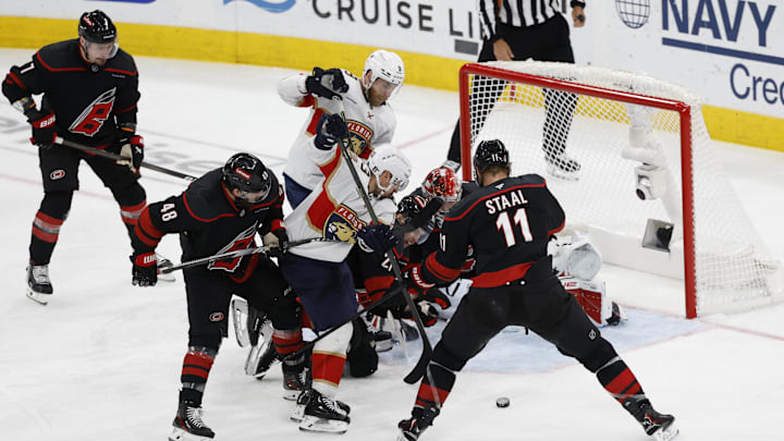 May 28, 2025; Raleigh, North Carolina, USA; Florida Panthers forward Brad Marchand (63) battles for the puck against Carolina Hurricanes forward Jordan Martinook (48) and forward Jordan Staal (11) during the third period in game five of the Eastern Conference Final of the 2025 Stanley Cup Playoffs at Lenovo Center. Mandatory Credit: Geoff Burke-Imagn Images