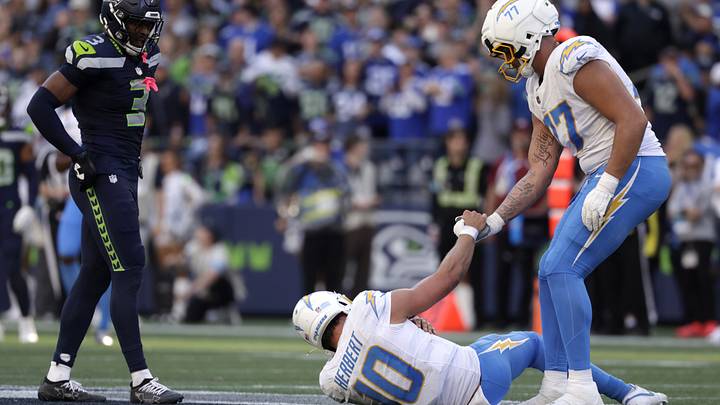 Oct 4, 2026; Seattle, Washington, USA; Los Angeles Chargers offensive tackle Travis Burke (77) helps Los Angeles Chargers quarterback Justin Herbert (10) to his feet against the Seattle Seahawks during the second half at Lumen Field. Mandatory Credit: Joe Nicholson-Imagn Images Oct 4, 2026; Seattle, Washington, USA; Los Angeles Chargers offensive tackle Travis Burke (77) helps Los Angeles Chargers quarterback Justin Herbert (10) to his feet against the Seattle Seahawks during the second half at Lumen Field. Mandatory Credit: Joe Nicholson-Imagn Images